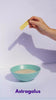 Stop motion of bowl of conjo congee with hand dropping herbs into it